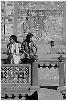 Young women sitting in the center of Ornamental pool. Fatehpur Sikri, Uttar Pradesh, India (black and white)