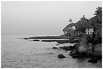 Boulders, beachfront house, and palm trees at sunrise. Goa, India ( black and white)