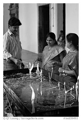 Man and two women burning candles, Basilica of Bom Jesus, Old Goa. Goa, India