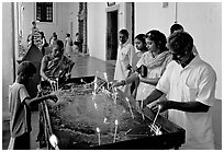 Indian people burning candles, Basilica of Bom Jesus, Old Goa. Goa, India ( black and white)