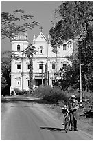 Man walking a bicycle in front of church of St John, Old Goa. Goa, India (black and white)