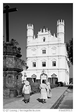 Women walking towards Church of St Francis of Assisi, afternoon, Old Goa. Goa, India