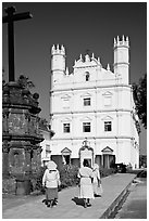 Women walking towards Church of St Francis of Assisi, afternoon, Old Goa. Goa, India (black and white)