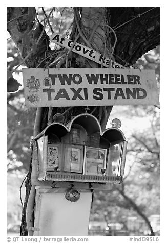Two wheeler taxi stand and altar on tree. Goa, India (black and white)