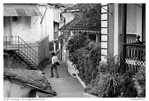 Man in alley with gardens, Panjim. Goa, India (black and white)