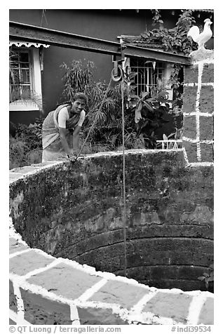 Woman retrieving water from well, Panaji. Goa, India (black and white)