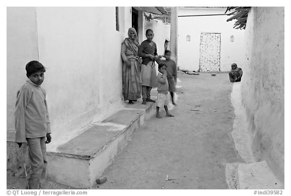 Family in village alley. Khajuraho, Madhya Pradesh, India (black and white)