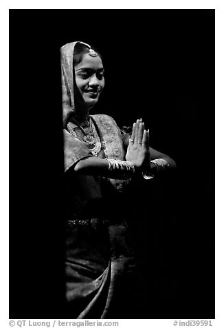 Woman joining hands in prayer gesture with dramatic lighting, Kandariya show. Khajuraho, Madhya Pradesh, India