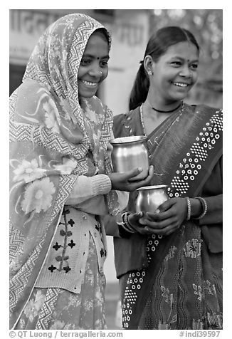 Women with pots used for religious offerings. Khajuraho, Madhya Pradesh, India (black and white)