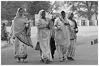Hindu women walking in street with pots. Khajuraho, Madhya Pradesh, India (black and white)