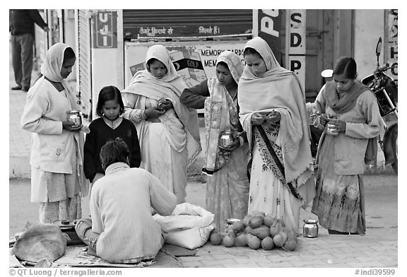 Hindu women purchasing offerings before going to temple. Khajuraho, Madhya Pradesh, India (black and white)