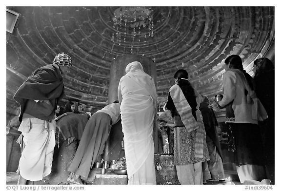 Worshipers and polished lingam inside Matangesvara temple. Khajuraho, Madhya Pradesh, India