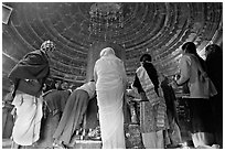 Worshipers and polished lingam inside Matangesvara temple. Khajuraho, Madhya Pradesh, India (black and white)