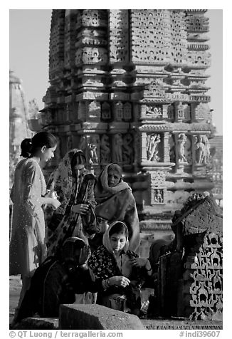Women offering morning puja  in front temple spire. Khajuraho, Madhya Pradesh, India (black and white)