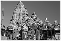 Worshippers making offering with Lakshmana temple behind. Khajuraho, Madhya Pradesh, India (black and white)