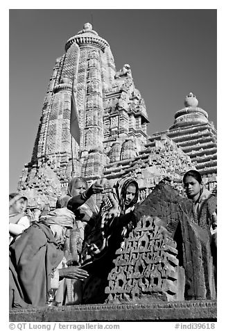 Hindu worshippers making offerings with Lakshmana temple behind. Khajuraho, Madhya Pradesh, India (black and white)