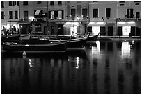 Light of shops reflected in harbor at dusk, Portofino. Liguria, Italy (black and white)