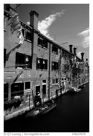 Resident stepping from his doorway to his boat,  Castello. Venice, Veneto, Italy