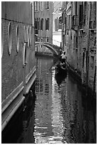 Gondola and reflections in a narrow canal. Venice, Veneto, Italy (black and white)