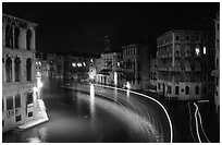 Light trails on the Grand Canal at night near the Rialto Bridge. Venice, Veneto, Italy (black and white)