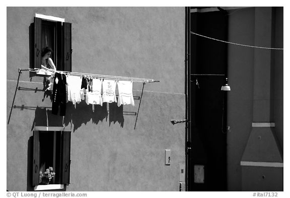 Woman hangs laundry to dry, Burano. Venice, Veneto, Italy (black and white)