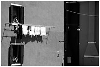 Woman hangs laundry to dry, Burano. Venice, Veneto, Italy (black and white)