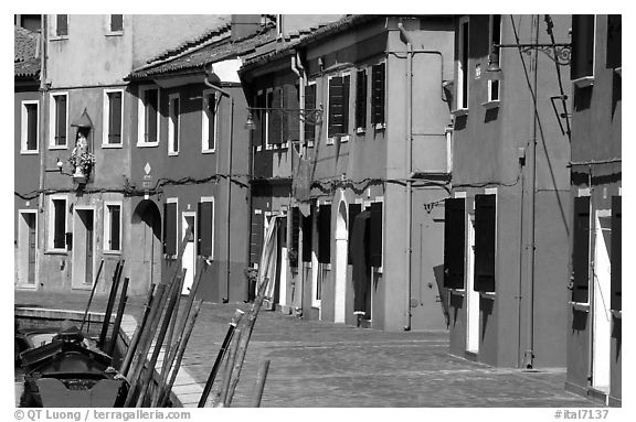 Sidewalk and row of brightly painted houses, Burano. Venice, Veneto, Italy (black and white)