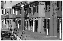 Sidewalk and row of brightly painted houses, Burano. Venice, Veneto, Italy (black and white)