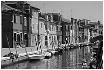 Canal lined with typical brightly painted houses, Burano. Venice, Veneto, Italy ( black and white)