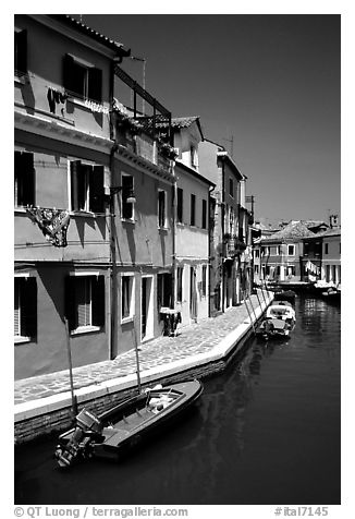 Canal surrounded by houses painted  a multitude of bright colors, Burano. Venice, Veneto, Italy