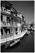 Canal surrounded by houses painted  a multitude of bright colors, Burano. Venice, Veneto, Italy (black and white)