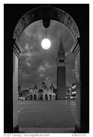 Campanile and Piazza San Marco (Square Saint Mark) seen from arcades at night. Venice, Veneto, Italy (black and white)