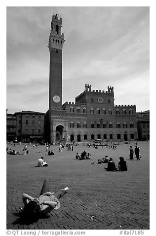 Tourist relaxes on Piazza Del Campo. Siena, Tuscany, Italy