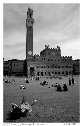 Tourist relaxes on Piazza Del Campo. Siena, Tuscany, Italy (black and white)