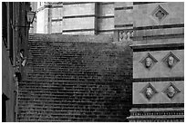 Woman cleaning up besides the Duomo stairs. Siena, Tuscany, Italy (black and white)