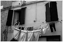 Woman hanging laundry. Siena, Tuscany, Italy (black and white)