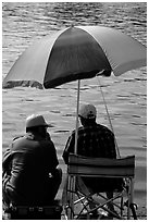 Men fishing under an colorful sun unbrella,  Agropoli. Campania, Italy ( black and white)