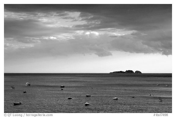 Small boats and Capri Island at sunset, Positano. Amalfi Coast, Campania, Italy (black and white)