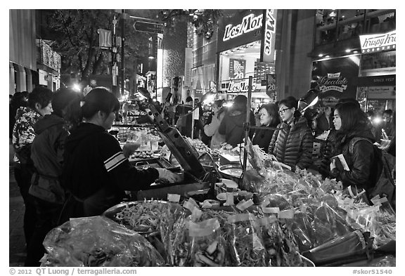 Unusual street foods on busy shopping street. Seoul, South Korea (black and white)