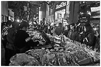 Unusual street foods on busy shopping street. Seoul, South Korea (black and white)