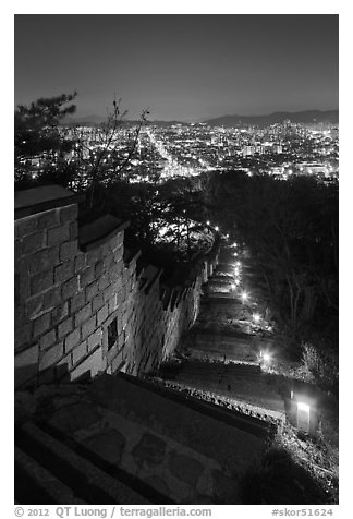 Path, wall, and city lights, Suwon Hwaseong Fortress. South Korea (black and white)