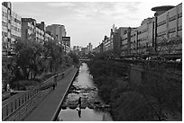 Pedestrians walking through Cheonggyecheon river park. Seoul, South Korea (black and white)