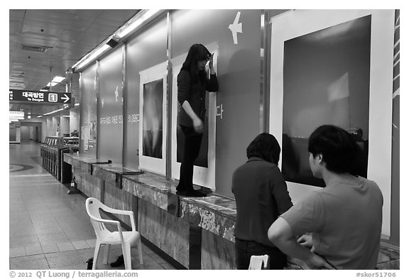 Photography exhibit being installed in subway. Daegu, South Korea (black and white)