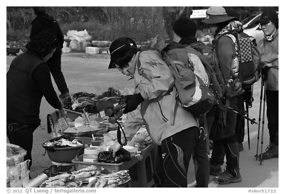 Hikers check out stand selling natural products. South Korea (black and white)