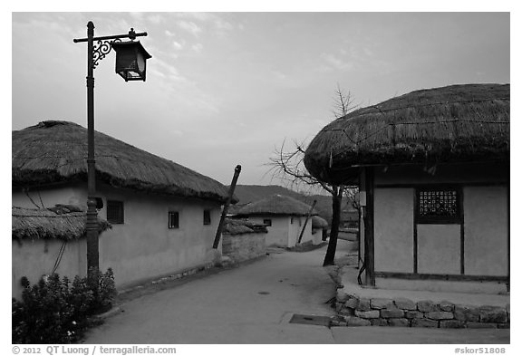 Alley bordered by straw roofed houses. Hahoe Folk Village, South Korea (black and white)