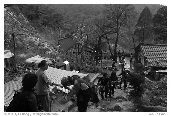 Hikers receiving sacred bread at Sangseonam hermitage, Mt Namsan. Gyeongju, South Korea (black and white)