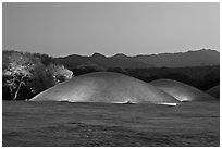 Illuminated tumuli at dusk and hills. Gyeongju, South Korea (black and white)