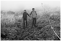 Couple hiking holding hands in fog. Jeju Island, South Korea ( black and white)