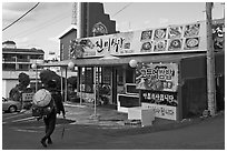 Haeneyo woman walking towards seafood restaurant. Jeju Island, South Korea ( black and white)