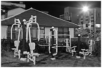 Exercise equipment in yard at night, Seogwipo. Jeju Island, South Korea (black and white)